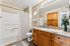 virtually staged bathroom with toilet, sink, tub, and towels.