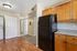 Kitchen with fridge, wooden counters, wooden floors, carpet, and laundry.
