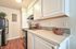 Modern kitchen workspace with a refrigerator and clean white counters at CAMPBELL PARK.