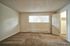 Clean, empty bedroom with neutral carpeting and a large window at CAMPBELL PARK.