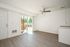 Open living space with wooden floor and ceiling fan and patio.