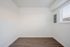 Bedroom with wooden floor and window and circuit breaker.