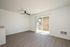 Living area with wooden floors, fan, patio, and vent.