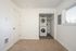 Bedroom with stackable washer and dryer with carpet and window.