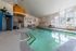 Large indoor pool space surrounded by relaxing deck lounge chairs at Berkeley Heights Apartment Homes.