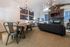 Expansive clubhouse community room with a dining table and sofa at Berkeley Heights Apartment Homes.