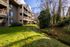 Multi-level apartment building exterior facing a grassy lawn at Creekwood Apartments.