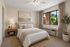 Virtually Staged bedroom at Orchard Mesa with a bed, dresser, tv and closet
