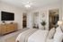 Virtually Staged bedroom at Orchard Mesa with a bed, dresser, tv and closet