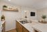Virtually staged kitchen at Orchard mesa with wood floors, white countertops and wood cabinets