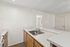 Kitchen at Orchard Mesa with wood cabinets, white appliances, white countertops and wood floors