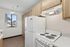 Kitchen at Orchard Mesa with wood cabinets, white appliances, white countertops and wood floors