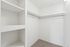 A walk-in closet with shelving and a rod to hang clothes