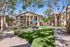 Courtyard at Orchard Mesa with grass, trees and seating with umbrellas