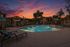 The pool at orchard mesa at sunset with seating and umbrellas