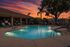 The pool at orchard mesa at sunset with seating and umbrellas