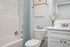 virtually staged bathroom with bath, toilet, sink, and mirror.