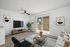 virtually staged living room with sofa, chair, table, tv, patio, ceiling fan, and artwork.