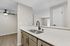 Kitchen with view into the living room and dining room with white countertops and black hardware