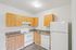 kitchen in the 1x1 floorplan at ventura villas with white appliances and woord cabinets
