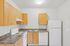 kitchen in the 1x1 floorplan at ventura villas with white appliances and woord cabinets
