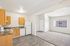 kitchen in the 1x1 floorplan at ventura villas with white appliances and woord cabinets with view into the living room