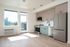 Kitchen and living room at Cedarline with wood floors, balcony and full fridge