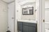 Bathroom at Deer Valley Village featuring a grey vanity, white sink, and framed mirror with modern light.