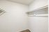Spacious white closet with hanging rods and shelves in a Deer Valley Village apartment.