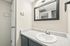 Detail of white bathroom sink and grey vanity with framed mirror at Deer Valley Village.