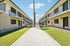 Deer Valley Village courtyard featuring a wooden walkway, green grass, and tall palm tree.