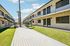 Landscaped courtyard at Deer Valley Village with a wooden walkway and lush green lawn.