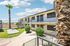 Two-story apartment building at Deer Valley Village with palm trees and metal staircases.
