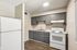 Kitchen at Deer Valley Village with grey cabinets, white electric range, and laminate countertops.