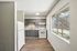 Open layout kitchen at Deer Valley Village with white appliances, grey cabinets, and wood-style flooring.