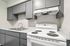 Detail of white electric range and grey upper cabinetry in a Deer Valley Village apartment kitchen.