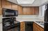 Kitchen at Silver Creek with black appliances and wood cabinets