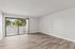Living room of a unit at Peoria Grand with wood floors and a sliding glass door to a patio