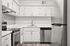 Kitchen at Peoria Grand with stainless steel appliances and all white cabinets