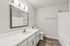 Bathroom with wood floors, shower/tub combo and white cabinets