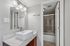 bathroom at solaris at the biltmore with wood cabinets and a white sink and a seperate room with toilet and shower