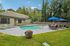 Pool at Creekwood with lounge chairs and tables with umbrellas