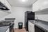 Kitchen at Creekwood with black appliances and grey marbled countertops
