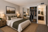 Virtually staged bedroom with two nightstands, arizona art and clothes in the closet