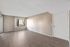 Open living area featuring neutral paint, wood-style floors, and natural light from a large window.