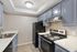 Kitchen at Solaris at Shadow Mountain with blue cabinetry, white counters, and black appliances.