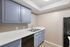 Modern kitchen featuring blue cabinets, white countertops, and a double stainless steel sink.