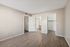 Bedroom view showing vinyl plank floors and open doors to the closet and bathroom areas.