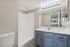 Bathroom at Solaris at Shadow Mountain with a blue vanity, white counter, and walk-in shower.