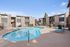 Gated swimming pool at Solaris at Shadow Mountain with blue lounge chairs and pool deck.
